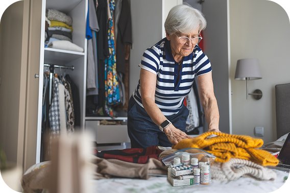 Woman packing clothes and medications for a trip