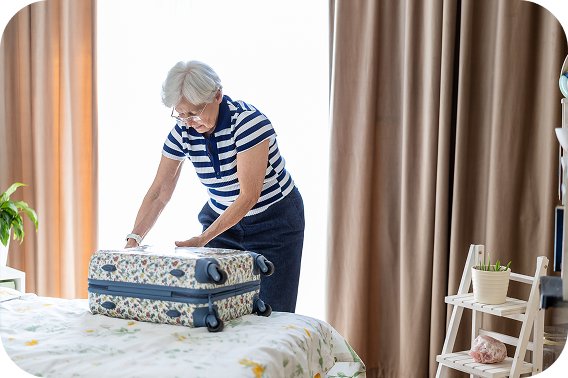 Woman packing a suitcase on her bed
